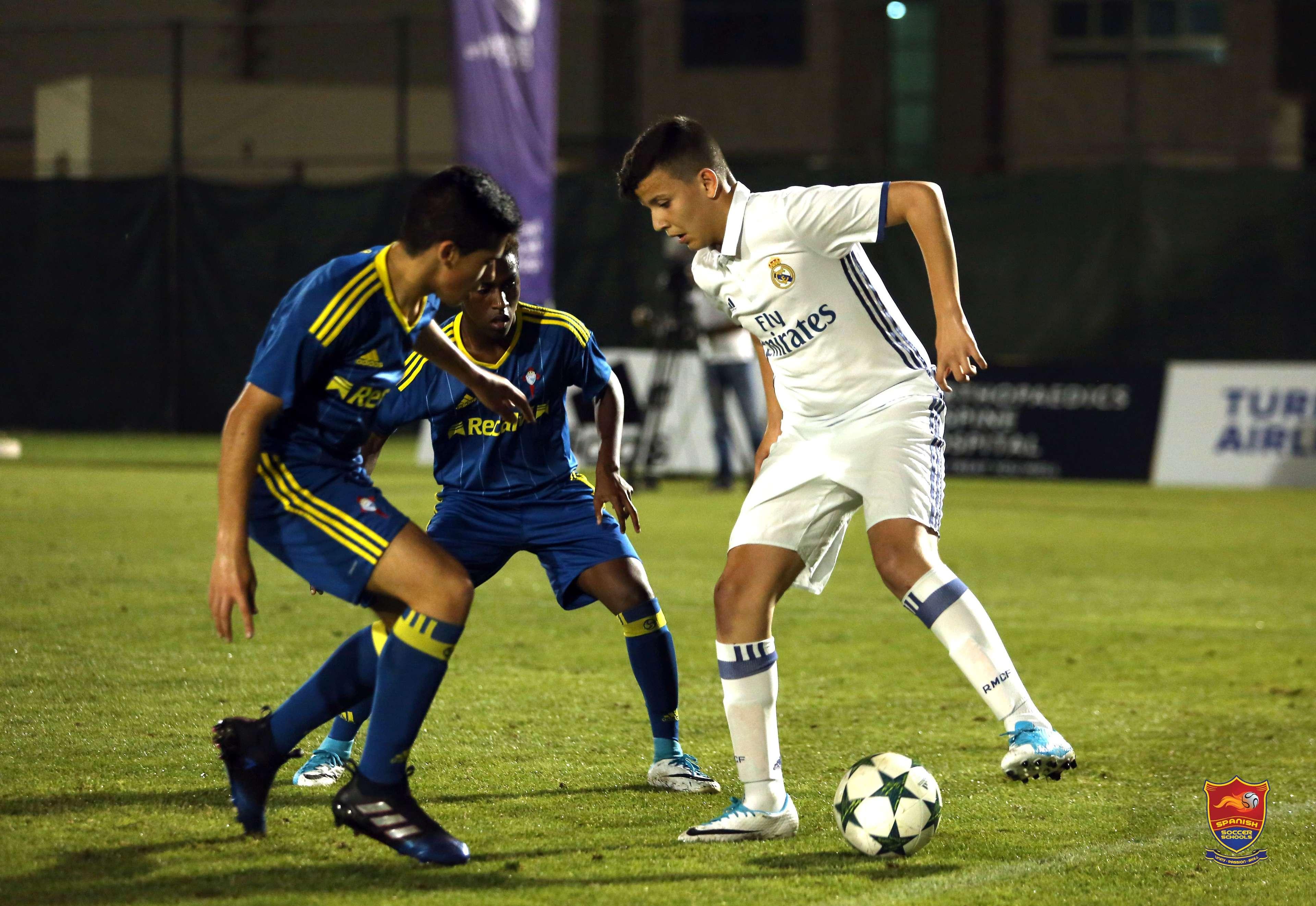 Young players contesting the ball during a night match.